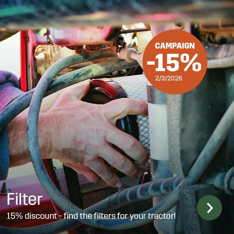 A hand installs a cylindrical filter inside a tractor engine compartment, surrounded by hoses and metal pipes. Sagros filter is used during tractor maintenance to ensure clean air or fuel flow in daily agricultural operations.