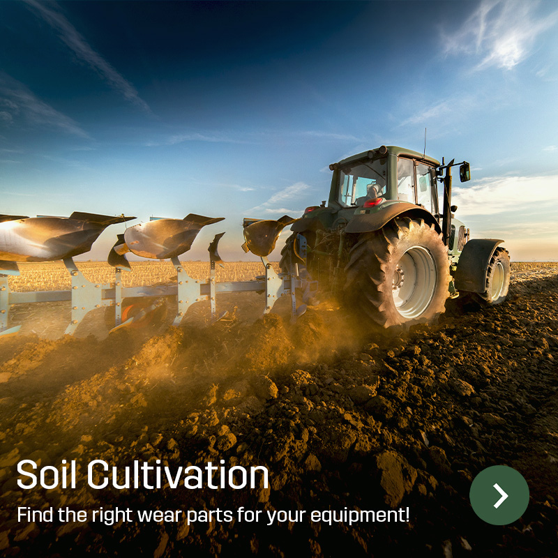 Tractor with a mounted plough working farmland and turning the soil as it drives. Sagros wear parts for soil cultivation equipment are used on implements for field work.