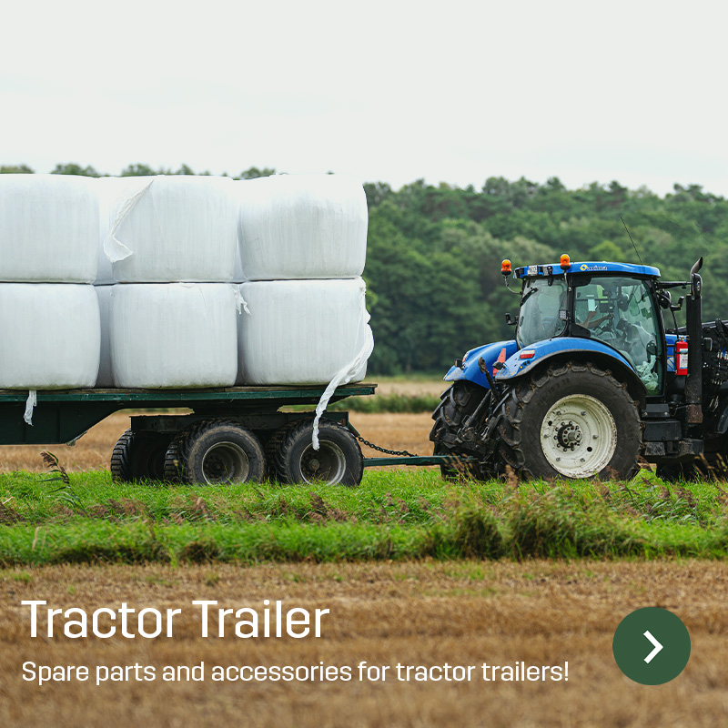 Blue tractor pulling a two-axle trailer loaded with white-wrapped bales across a field. The image shows a tractor trailer in agricultural use, a type of equipment for which Sagros supplies wear parts, spare parts and accessories.